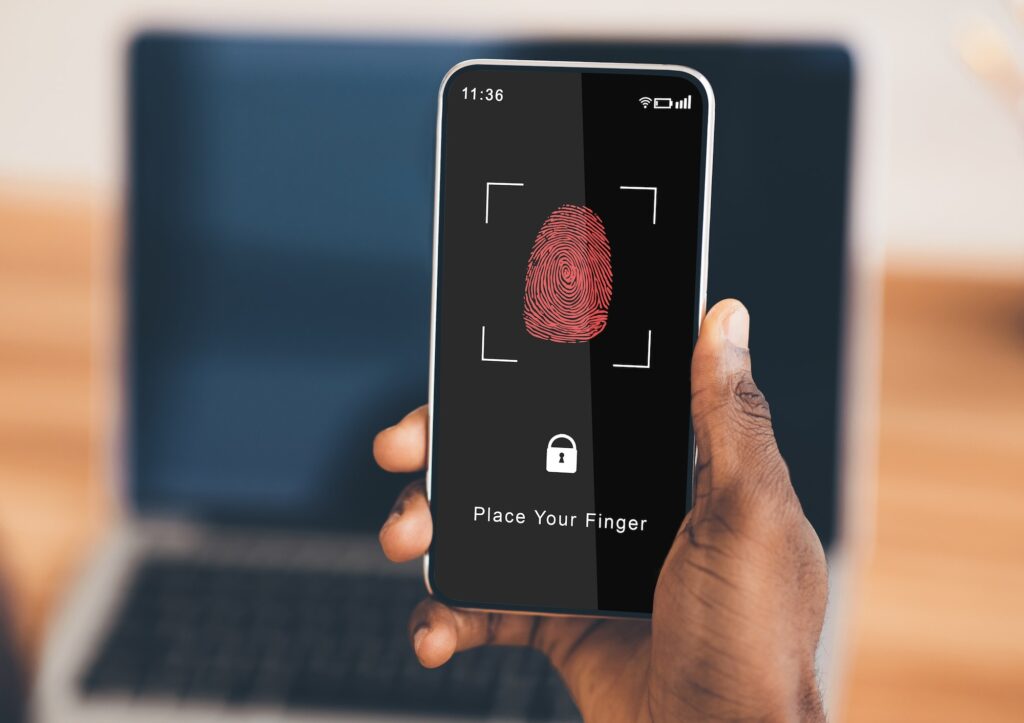 Black man holding phone with fingerprint scanning app