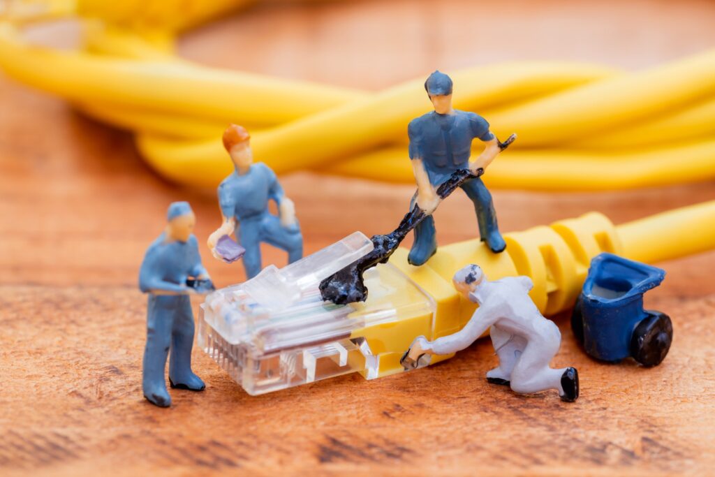 Close up miniature technician teamwork maintenance rj45 with network cable.